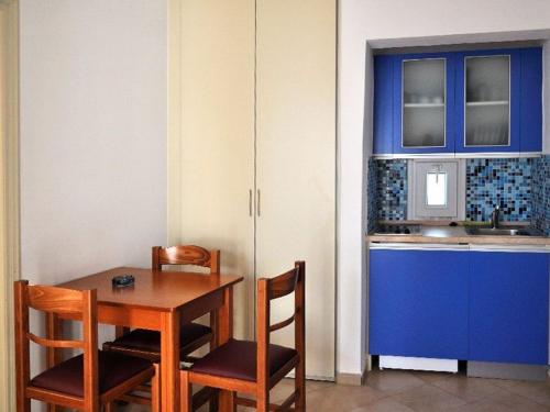 アギアアンナ・ナクソスにあるStudios Gabrielのキッチン(テーブル、椅子、青いキャビネット付)