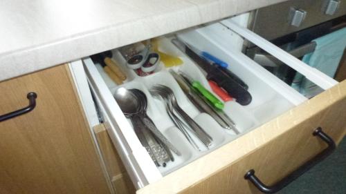a drawer in a cabinet filled with utensils at Apartament Leśny in Szczejkowice