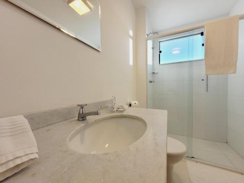 a bathroom with a sink and a glass shower at Pinda Palace Hotel in Pindamonhangaba