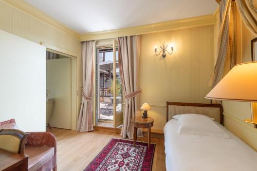 a small bedroom with a bed and a window at Le Manoir Au Lac in Gérardmer