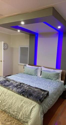 una camera da letto con un letto con luci blu di Made Guest House a Sandton
