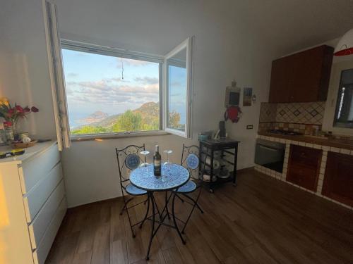 een keuken met een tafel en stoelen en een raam bij David in Cefalù