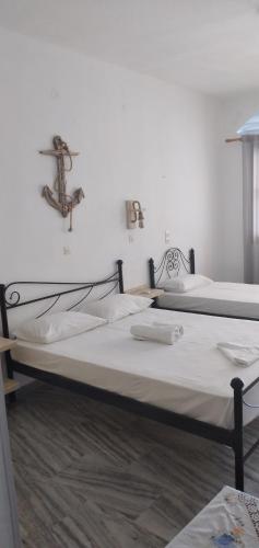 two beds in a room with white walls at Athina Studio Apartments in Kerveli