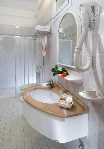 a white bathroom with a sink and a mirror at Hotel Garden - Parking Included in Bellaria-Igea Marina