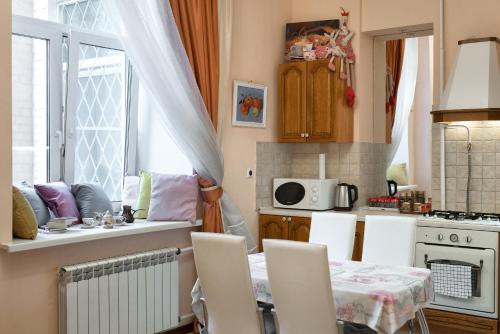 uma cozinha com uma mesa e cadeiras numa cozinha em Premium Apartment Old Arbat em Moscou