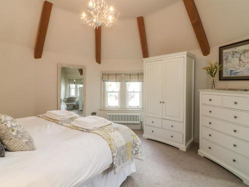 een slaapkamer met een wit bed en een kroonluchter bij Lonsdale Cottage in Carnforth
