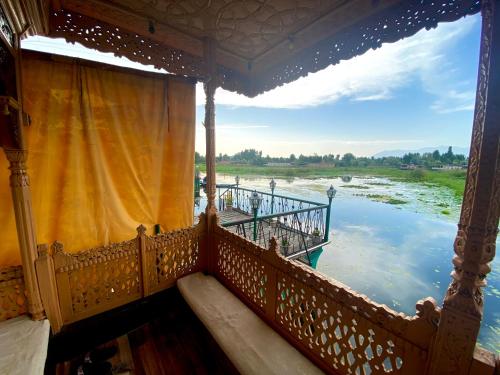 シュリーナガルにあるGreen Paradise Houseboat - Centrally Heatedの川の景色を望むバルコニー