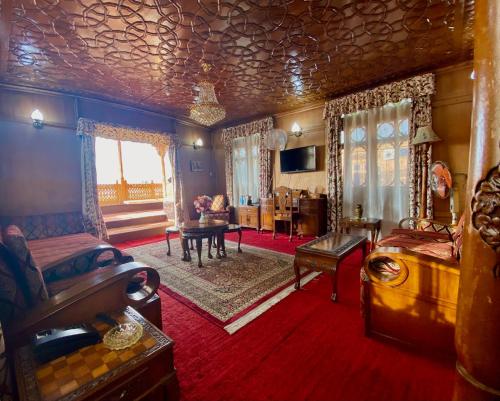 Green Paradise Houseboat - Centrally Heated في سريناغار: غرفة كبيرة بها سرير وغرفة معيشة