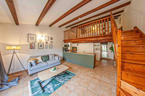 ein Wohnzimmer mit einem Sofa und einer Treppe in der Unterkunft Charmant studio/T2 au calme avec jardin et parking in Fos-sur-Mer