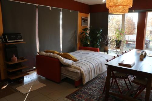 a bedroom with a bed and a desk and a table at Gesves Côté Jardin in Gesves