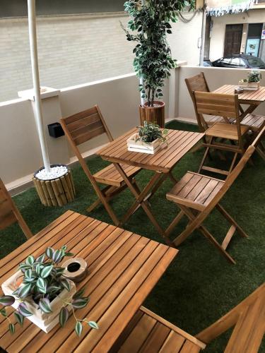 a patio with tables and chairs and potted plants at SUITE BLANC APARTMENTS - Monolocali indipendenti con cucina e bagno privato - Check-in e check-out con codice in autonomia h24 - Terrazza in comune NECESSARIO AVERE WATHSAPP O APP DI MESSAGGISTICA ISTANTANEA PER FOTO E VIDEO in Guspini