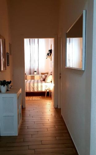 a hallway with a room with a bed and a window at SUITE BLANC APARTMENTS - Monolocali indipendenti con cucina e bagno privato - Check-in e check-out con codice in autonomia h24 - Terrazza in comune NECESSARIO AVERE WATHSAPP O APP DI MESSAGGISTICA ISTANTANEA PER FOTO E VIDEO in Guspini
