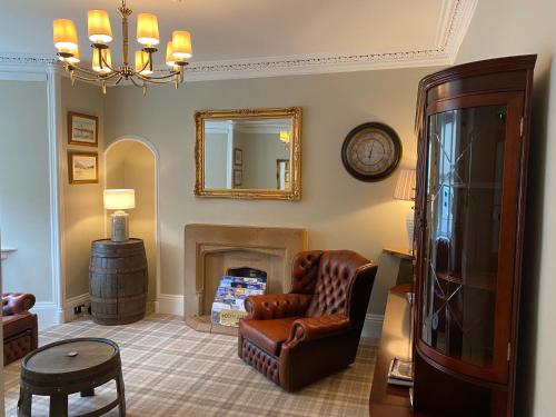a living room with a chair and a mirror at Adrian's Guest House in Inverness