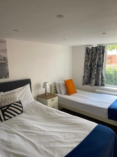 um quarto com 2 camas e uma janela em The Cambridge Suites - Tas Accommodations em Cambridge