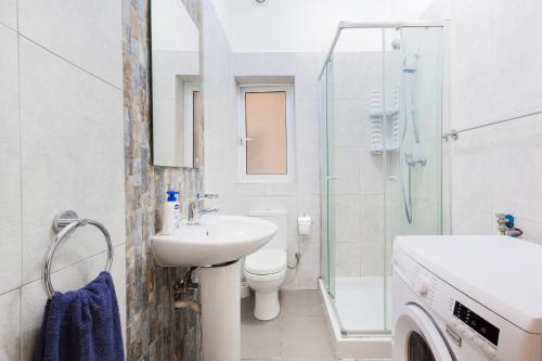 Un baño con lavabo, inodoro y ducha. en PC3- Centrally Located Apt-Close to University, en Msida