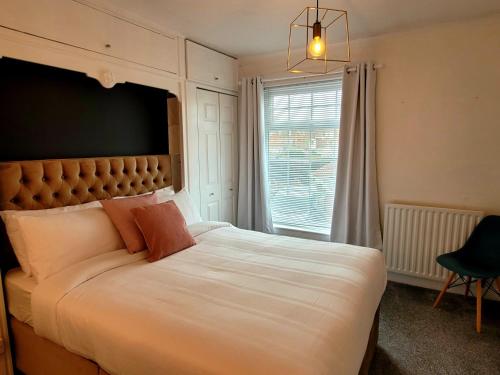a bedroom with a large white bed with a large window at The little seaside cottage in Bridlington