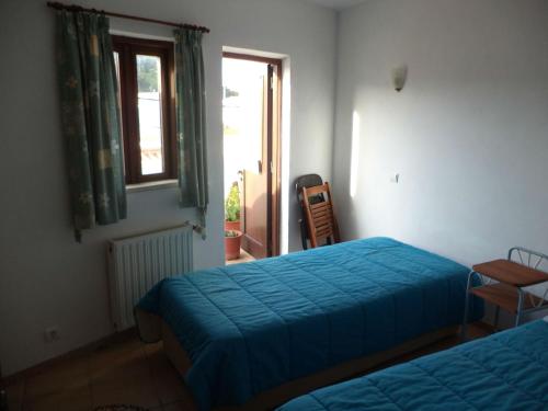 een slaapkamer met twee bedden en een raam bij Casa do João in Barão de São João