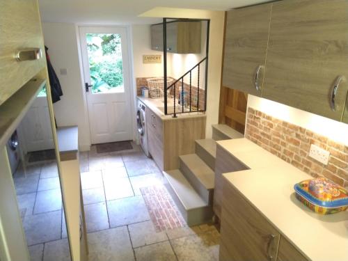 a kitchen with a staircase leading to a door at The woodstore in Dunkeswell