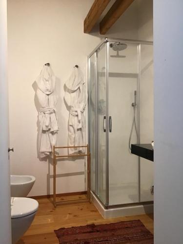 a bathroom with a shower and white towels hanging on a wall at La Foresteria di Villa Gorgo in San Vito al Torre