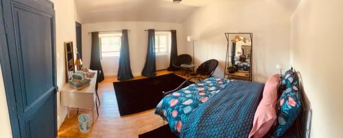 une chambre avec un lit et un salon dans l'établissement Le bistrot de l'écluse, à La Roussiere