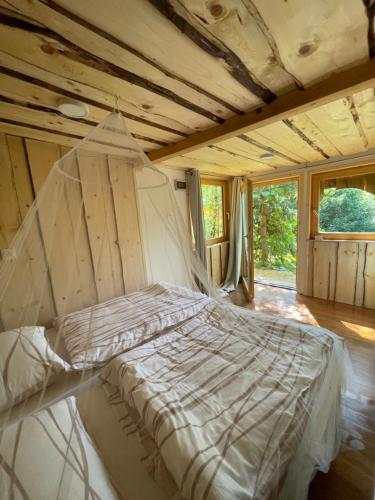 a white bed in a room with windows at Boutique Glamping Divja DiVine in Zgornja Korena
