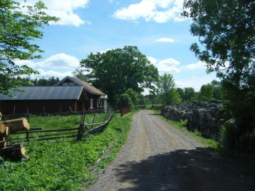 a dirt road next to a barn and a fence at Ekhaga, Hultåkra in Mariannelund
