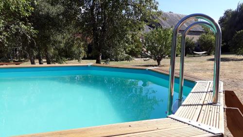 - une piscine bleue avec un banc à côté dans l'établissement La Villonnière, à Parnac