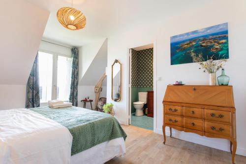 um quarto com uma cama e uma cómoda e uma casa de banho em La Bellevue Bréville - B&B em Bréville-sur-Mer