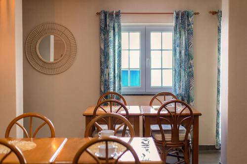 ein Esszimmer mit Tisch und Stühlen und einem Fenster in der Unterkunft Blue Bamboo Hotel - Duna Parque Resorts & Hotels in Vila Nova de Milfontes