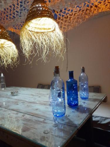 three blue bottles sitting on a table with lights at La Pluma in Iznájar