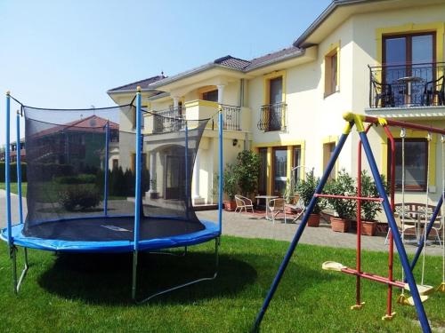 un parque infantil en el patio de una casa en Apartmány Family Veľký Meder, en Veľký Meder