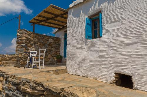 a white building with a blue window and a stone wall at Spiti Anita, Superior Master & Double Room - Pristine, Serene, Beautiful Views in Gavrion
