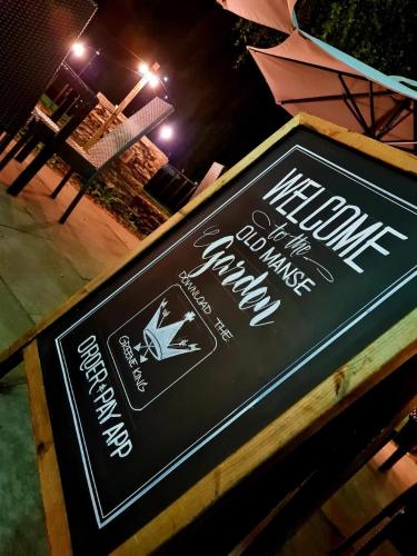 a sign for a restaurant on a table at night at Old Manse Hotel by Greene King Inns in Bourton on the Water