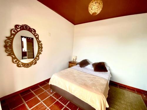 a bedroom with a bed and a mirror on the wall at Las Palmas Finca Turística in Filandia