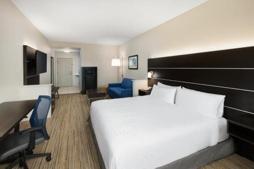a hotel room with a bed and a desk and chair at Holiday Inn Express & Suites - Valdosta by IHG in Valdosta