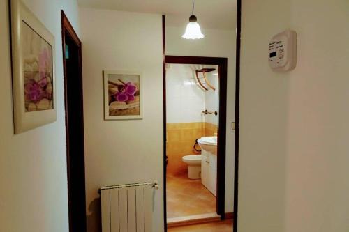 a bathroom with a toilet and a door leading to a hallway at Casa Albina in Ríofabar