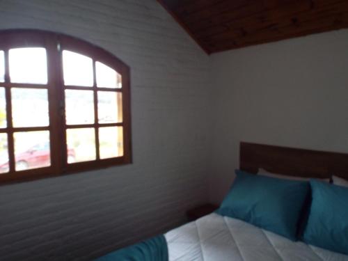 a bedroom with a bed and a window at Chale 66 em Monte Verde in Monte Verde