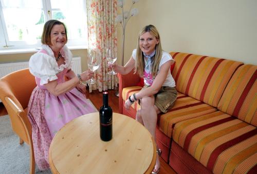 ファイステナウにあるAppartement Bergblick Iの二人の女の子がワインを飲みながらソファに座っている