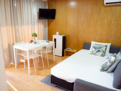 a room with a bed and a table with a white bed and a desk at Horizonte Monte Verde in Mondim de Basto