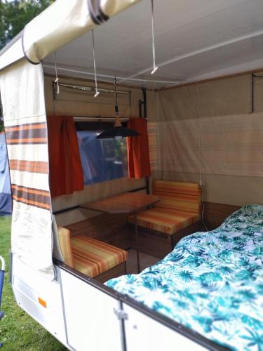 a bedroom and a bed in a trailer at Retro Vouwwagen in Tynaarlo