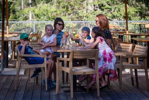a woman and her children sitting at a table at Hotel Björnson & Björnson TREE HOUSES Jasná in Demanovska Dolina