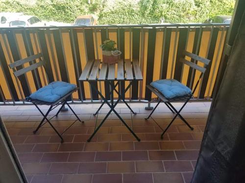2 chaises et une table avec une plante sur une terrasse couverte dans l'établissement Studio Mag'Aline, à Saint-Cyr-sur-Mer