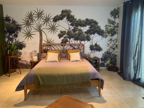 a bedroom with a bed with a painting on the wall at Chambre en Drôme Tropicale in Chabeuil