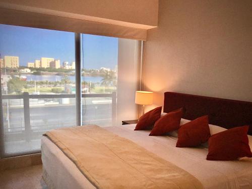 a bedroom with a large bed with a large window at Oceanview Luxury, Pool, Near Tour Boats & Beach in Puerto Vallarta