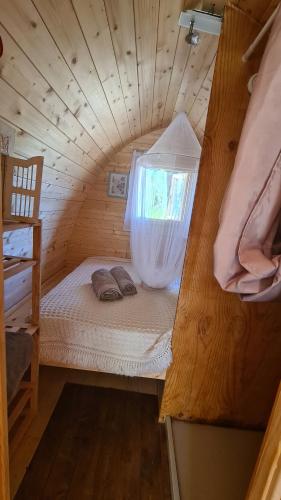 a small bed in a wooden room with a window at Gîte atypique : Le Pod in Carbuccia