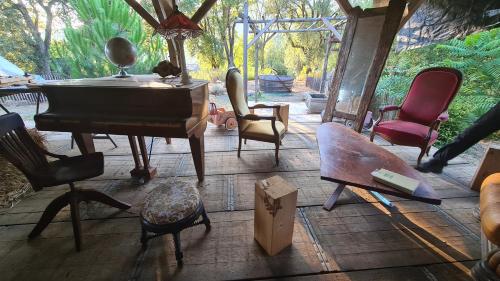 a group of chairs and a piano in a room at Gîte atypique Le Pod au coeur du maquis in Carbuccia