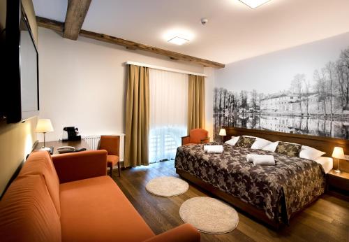 Habitación de hotel con cama y sofá en Hotel Tvrz Orlice, en Letohrad