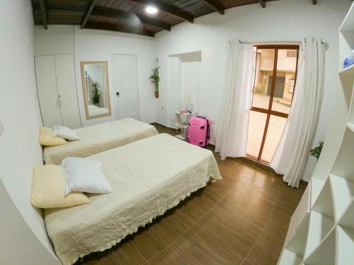 タラポトにあるNature & Travelersのベッド2台とピンクのスーツケースが備わるお部屋