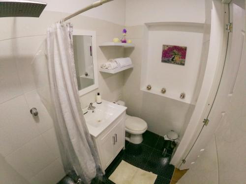 タラポトにあるNature & Travelersの白いバスルーム(トイレ、シンク付)