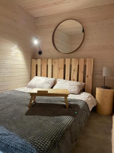 a bedroom with a bed with a wooden headboard and a mirror at XOXO Lake House in Giżycko